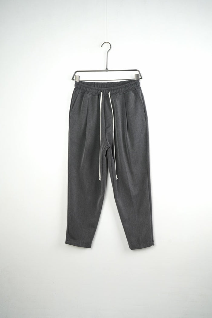 Pantaloni gri carrot fit pentru bărbați, cu talie elastică și șnururi albe, vedere frontală integrală pe umeraș