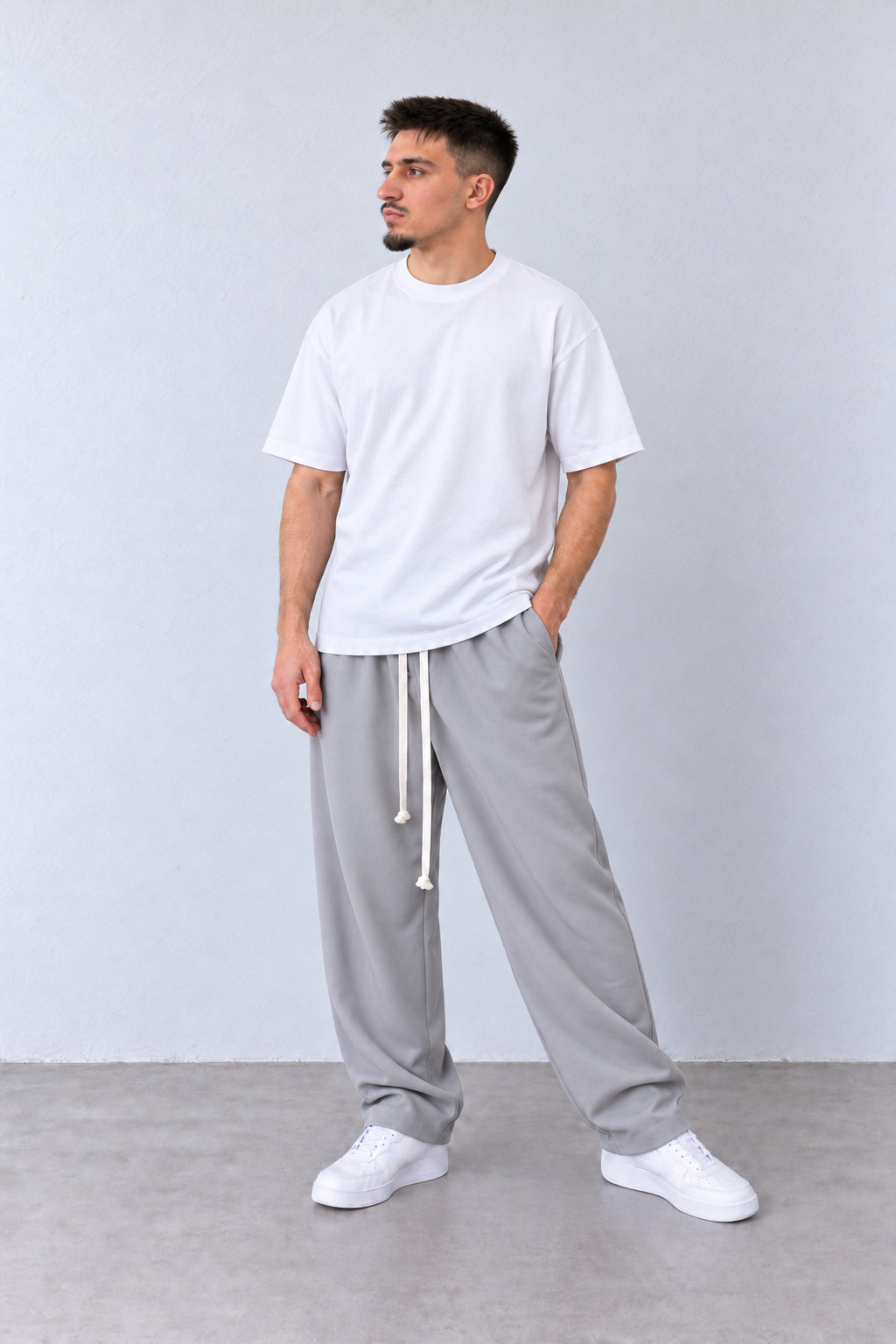 Pantaloni Bărbați Gri Deschis Largi cu Șnur Lung, vedere integrală pe model cu capul ușor întors sau înclinat.