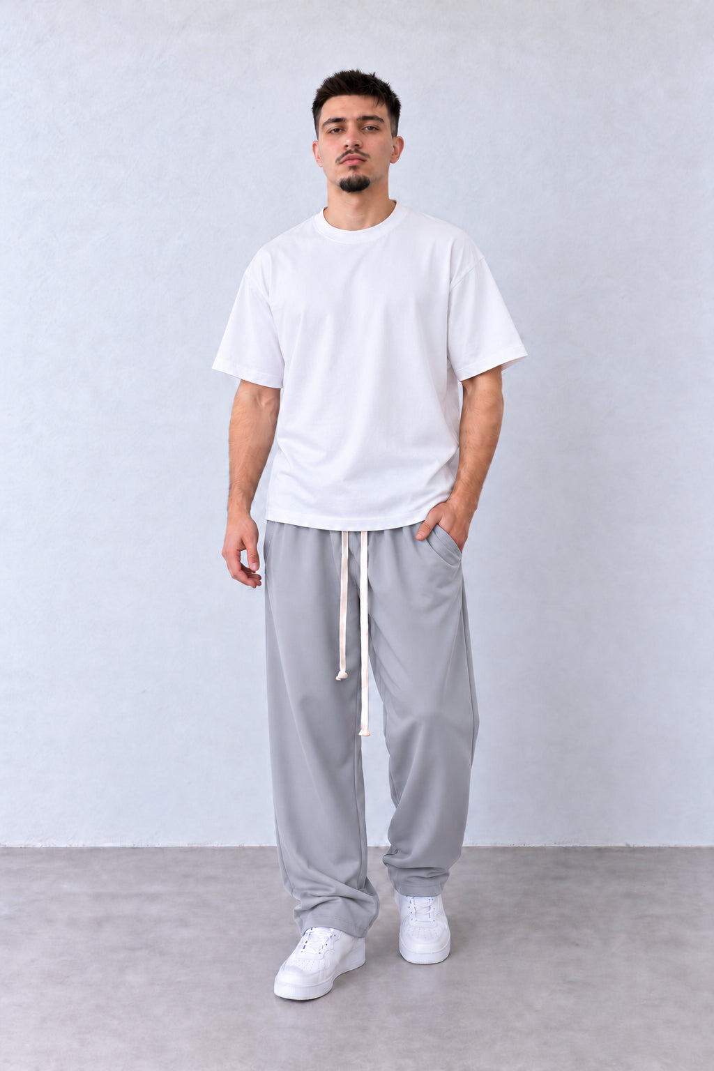 Pantaloni Bărbați Gri Deschis Largi cu Șnur Lung, vedere pe model cu poziție alternativă a brațelor și picioarelor.