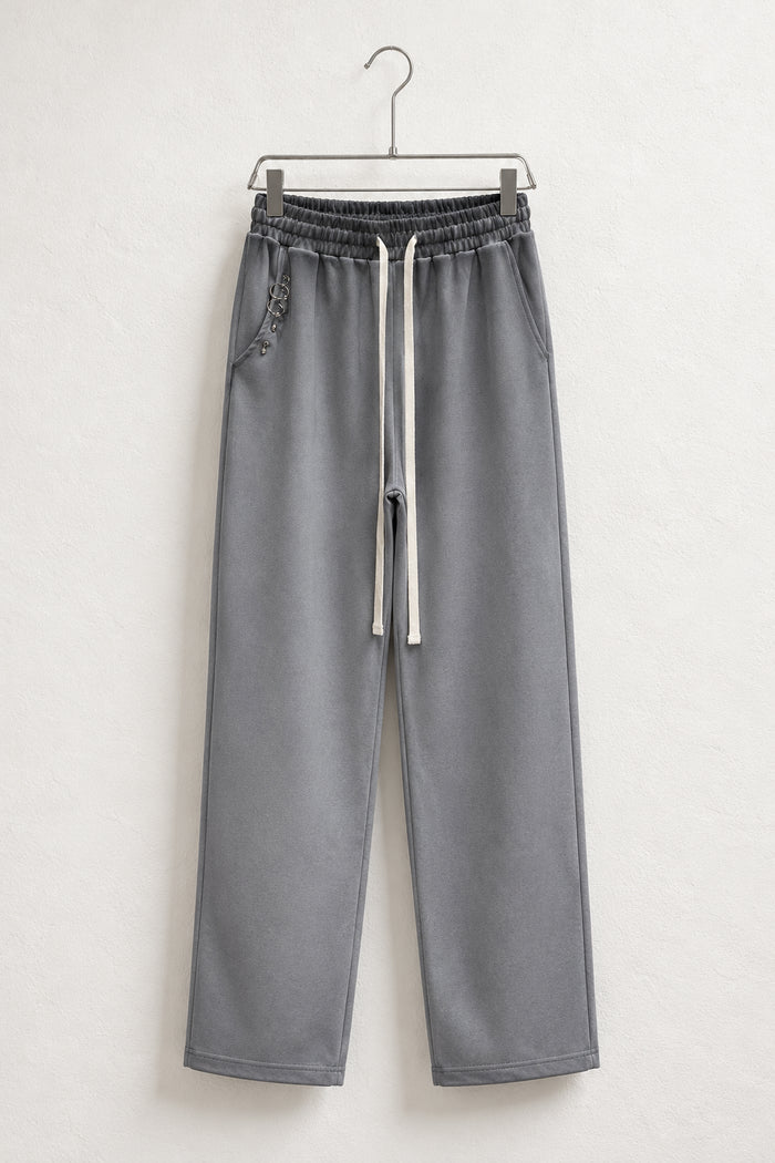 Pantaloni Bărbați Gri Largi cu Inele Decorative, vedere frontală completă pe umeraș metalic.