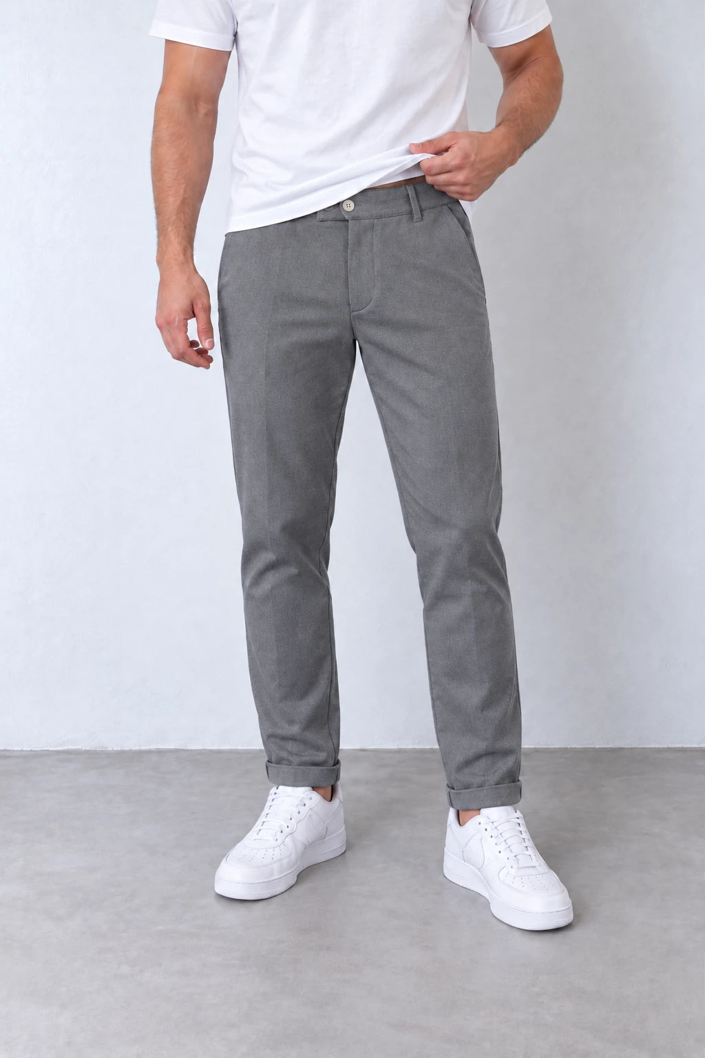Pantaloni slim gri pentru bărbați, vedere frontală apropiată cu nasture, găici pentru curea și tiv cu rever.