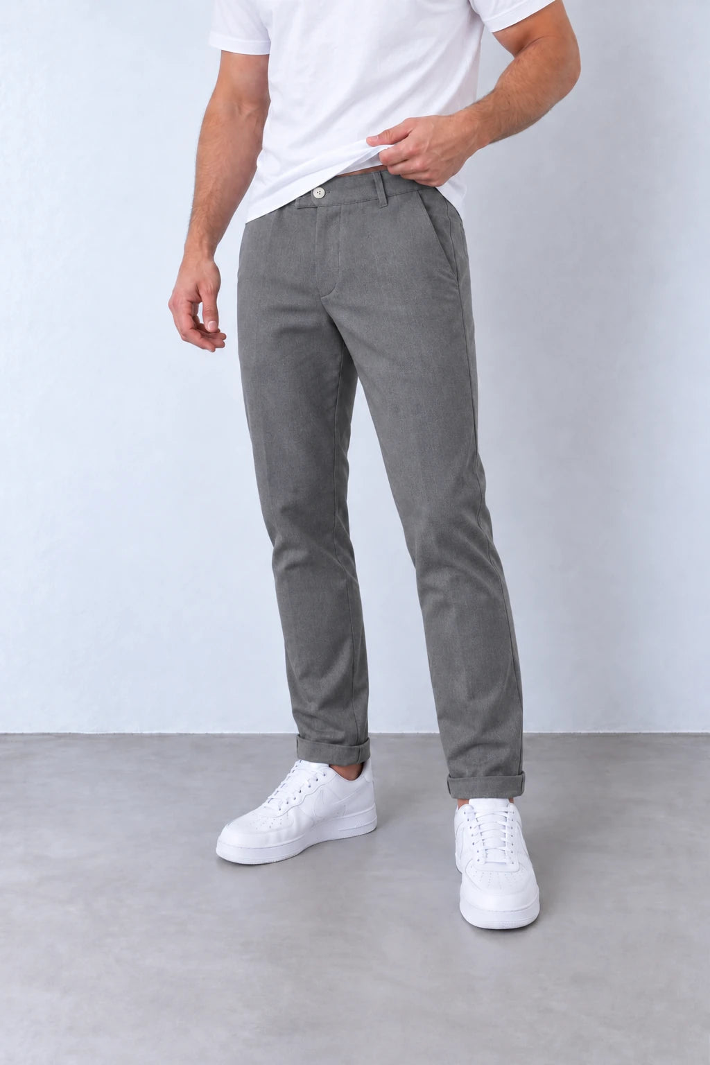 Pantaloni gri slim fit pentru bărbați, vedere din trei sferturi, cu buzunare oblice și tiv cu rever.