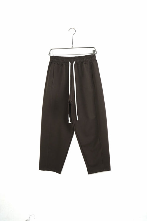 Pantaloni maro baggy pentru bărbați, cu șnururi albe și cusături laterale, vedere frontală integrală pe umeraș