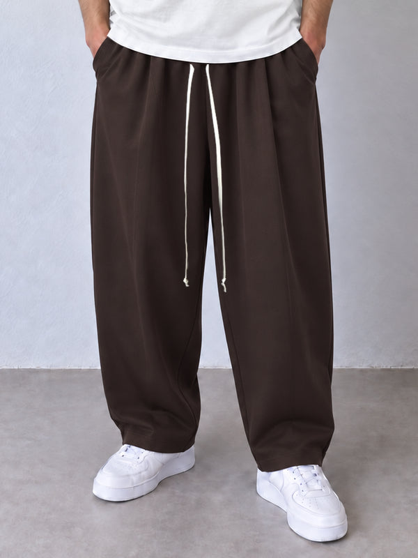 Pantaloni maro, cadru frontal apropiat cu șnur lung și terminații simple la glezne.