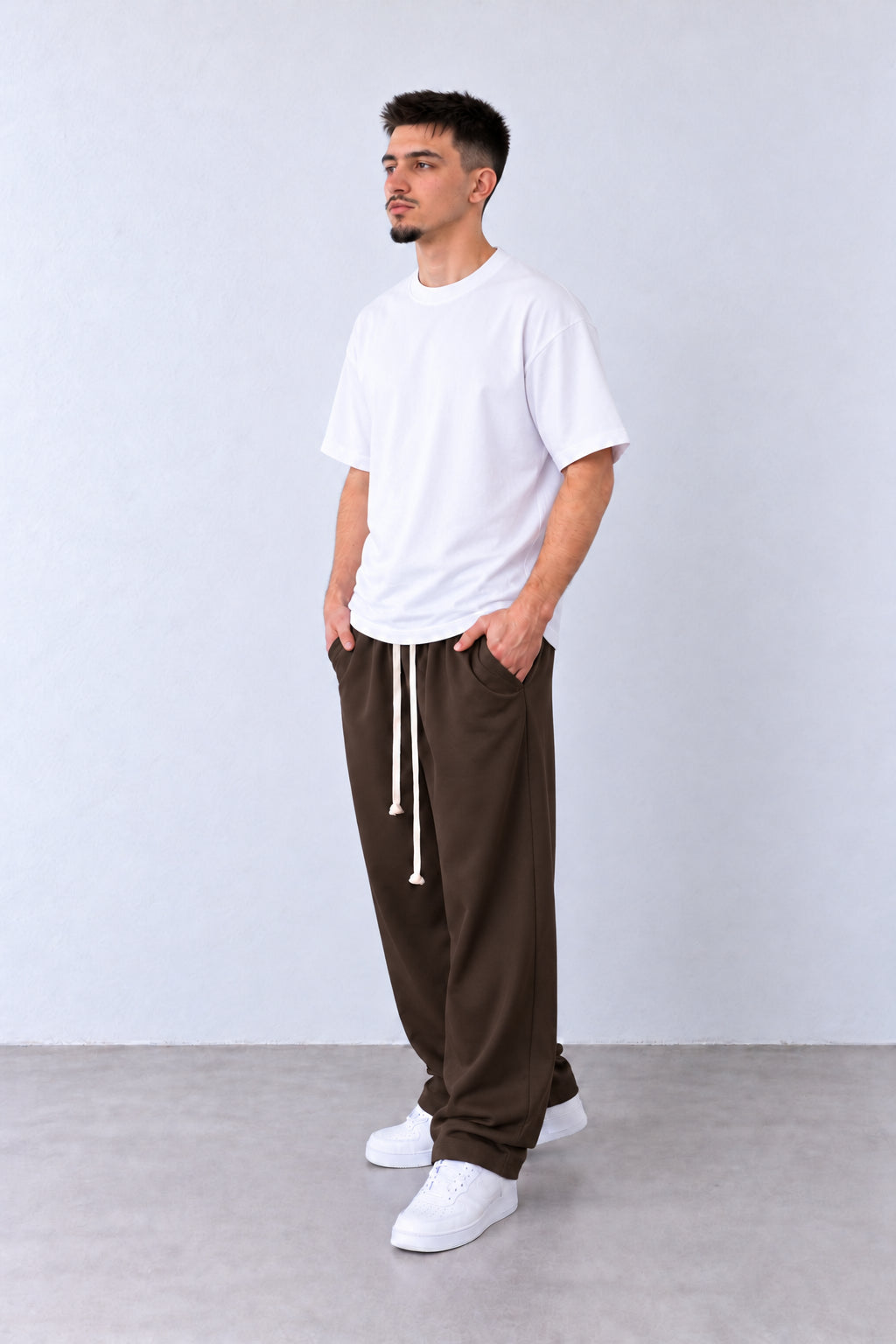 Pantaloni Bărbați Maro Închis Largi cu Șnur Lung, vedere pe model cu poziție alternativă a brațelor și picioarelor.