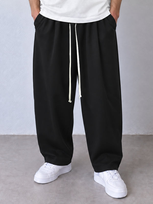 Pantaloni negri, cadru frontal apropiat cu șnur lung și terminații simple la glezne.