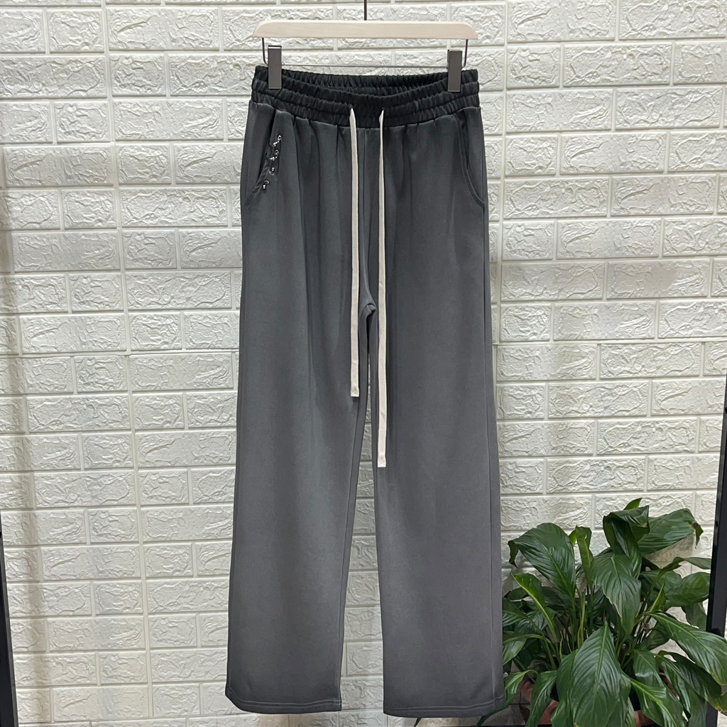 Fotografie reală a pantalonilor negri cu gradient, talie neagră elastică, șnururi lungi ivoire și accesorii metalice mici la buzunar