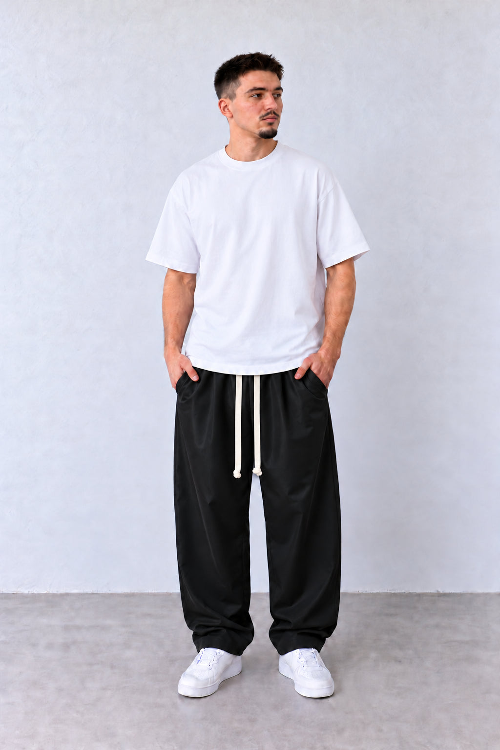 Pantaloni Bărbați Negri Largi Barrel Fit, vedere pe model cu poziție alternativă a brațelor și picioarelor.