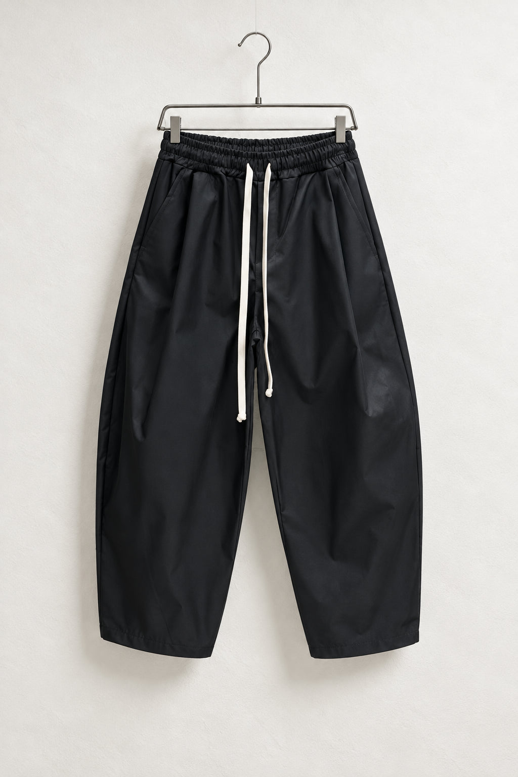 Pantaloni Bărbați Negri Largi Barrel Fit, vedere frontală completă pe umeraș metalic.