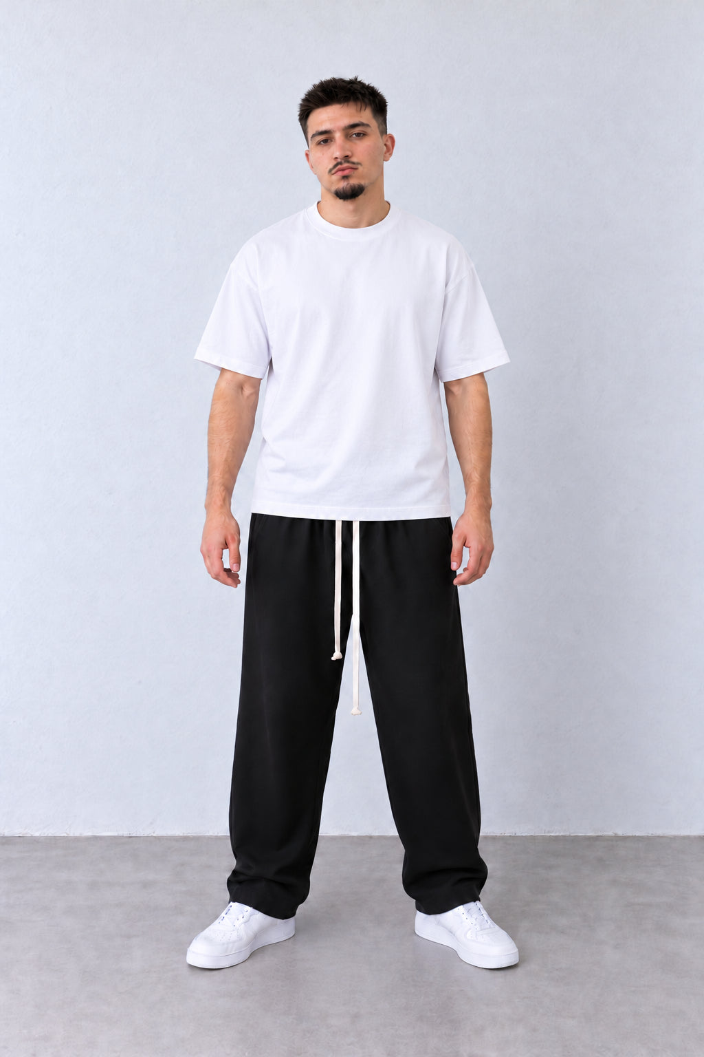 Pantaloni Bărbați Negri Largi cu Șnur Lung, vedere pe model cu poziție alternativă a brațelor și picioarelor.