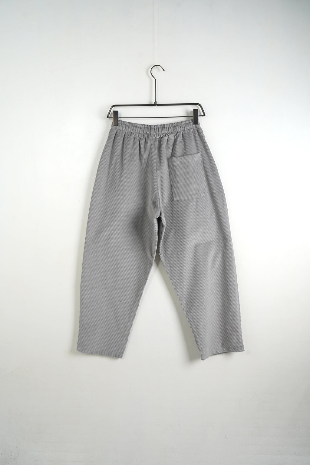 Model de pantaloni cu șnur lung decorativ, textură raiată gri deschis și croială wide leg urbană