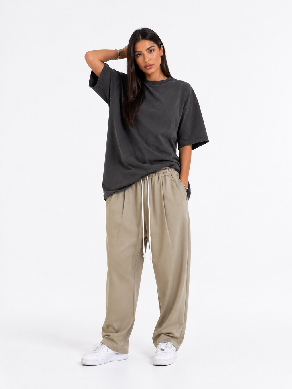 Manechin feminin purtând pantaloni bej lejeri cu talie elastică și șnur lung alb, croială casual oversized.