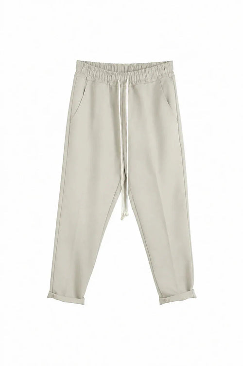 Detaliu talie elastică și șnur la pantalonii slim crem pentru bărbați