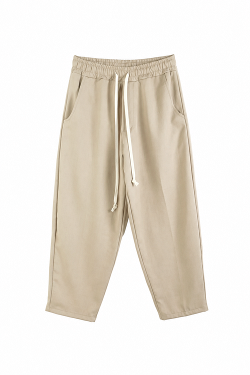Pantaloni crem slim cu șiret lung și talie elastică, ideali pentru outfituri casual moderne și confortabile.