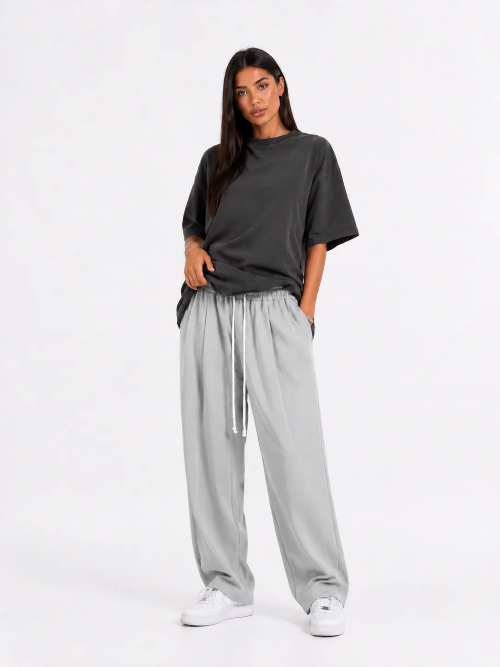 Model feminin cu pantaloni gri cu șnur lung și croială lejeră pentru outfituri trendy.
