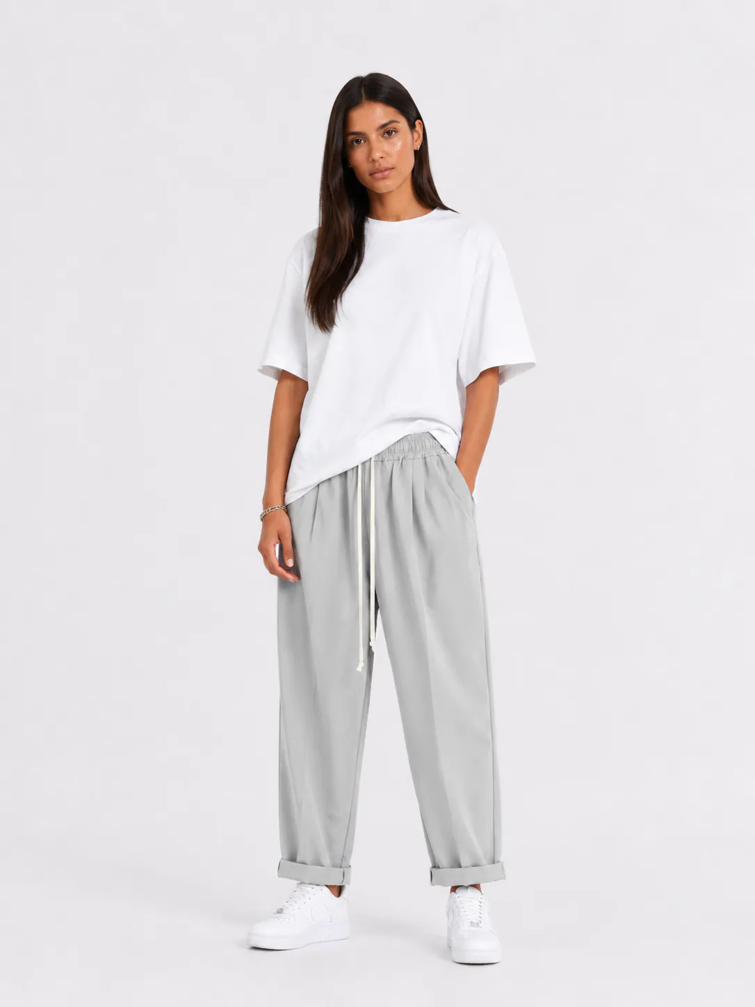 Femeie purtând pantaloni gri cu șiret lung într-un look casual modern și confortabil.