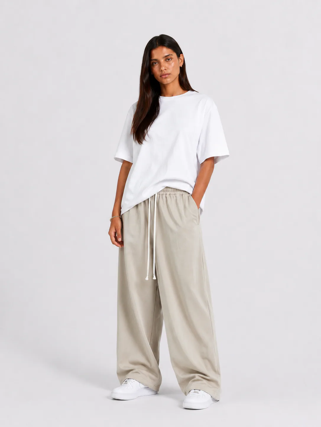 Femeie purtând pantaloni crem cu șiret lung într-un look casual modern și relaxat.