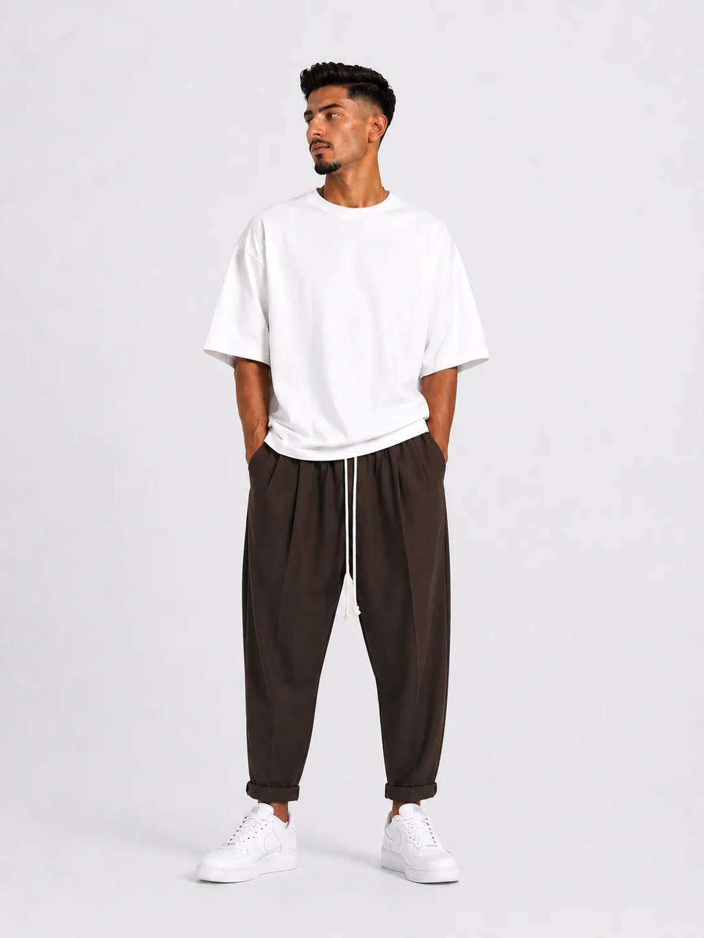Bărbat purtând pantaloni maro slim cu șiret lung într-un outfit streetwear modern și relaxat.