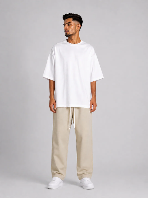 Outfit bărbătesc streetwear cu pantaloni crem și siret lung pentru stil contemporan.