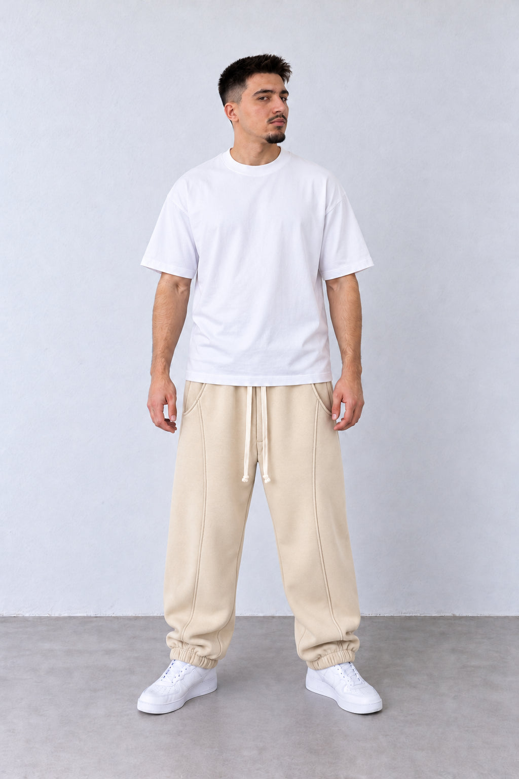 Pantaloni Jogger Balloon Fit Bărbați Bej, vedere pe model cu poziție alternativă a brațelor și picioarelor.