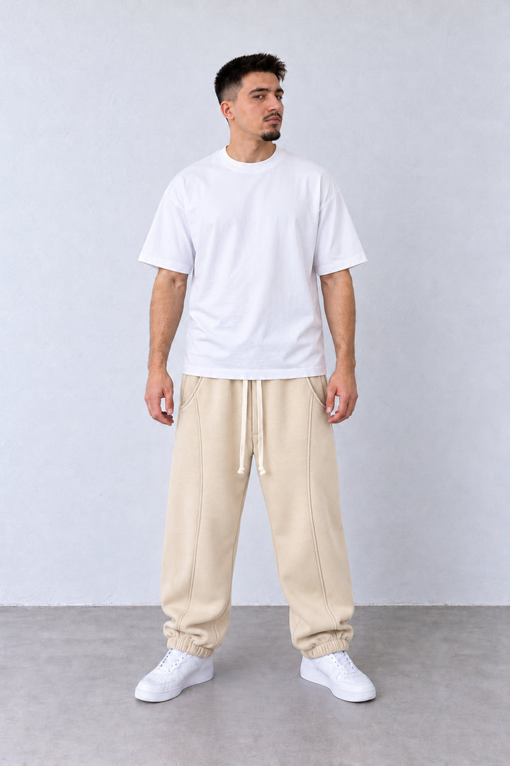 Pantaloni Jogger Balloon Fit Bărbați Bej, vedere pe model cu poziție alternativă a brațelor și picioarelor.