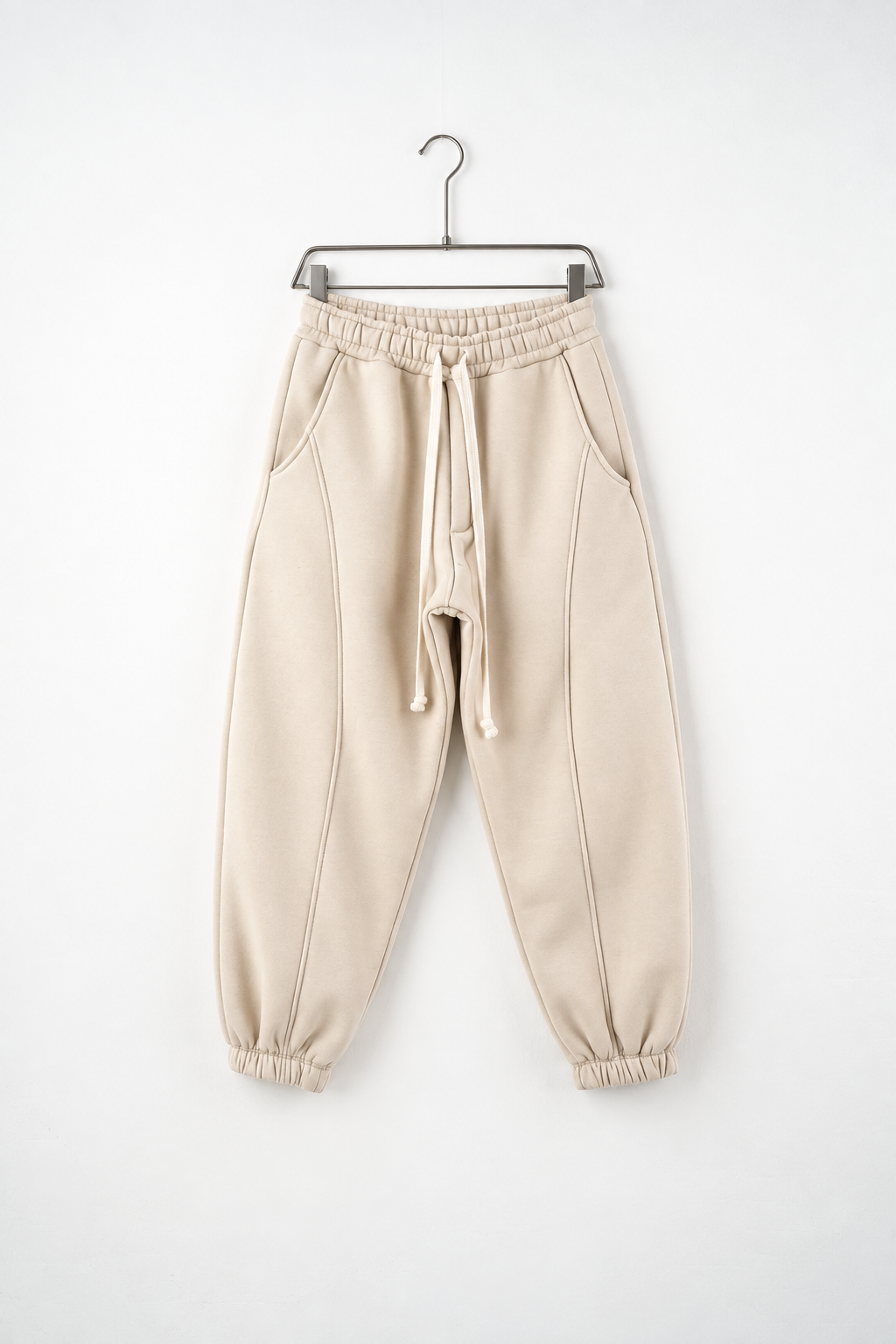 Pantaloni Jogger Balloon Fit Bărbați Bej, vedere frontală pe umeraș, fundal deschis