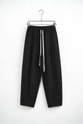 Pantaloni lungi negri carrot fit pentru bărbați, cu talie elastică și șnur alb lung, vedere frontală pe umeraș metalic cu cleme.