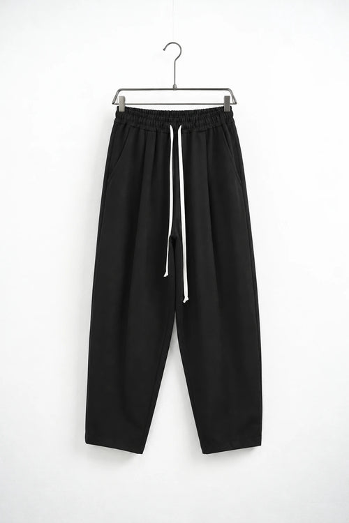 Pantaloni lungi negri carrot fit pentru bărbați, cu talie elastică și șnur alb lung, vedere frontală pe umeraș metalic cu cleme.