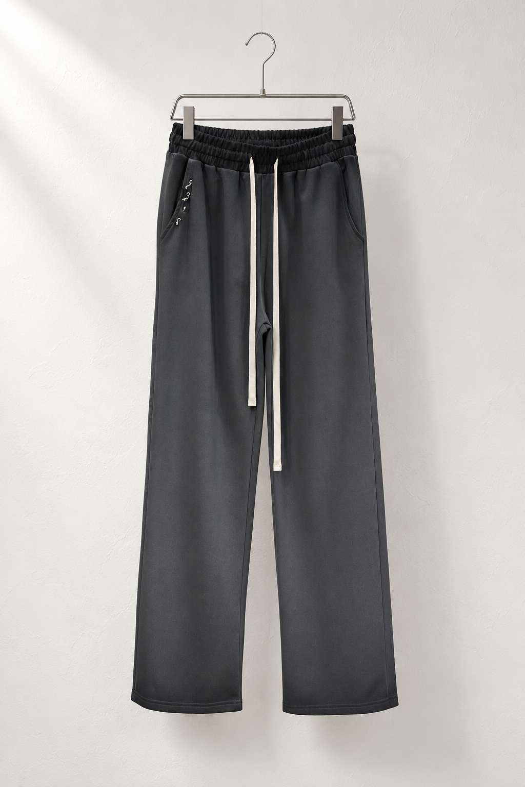 Pantaloni negri cu gradient pe umeraș metalic, talie închisă, șnururi ivoire și accesorii mici la buzunar