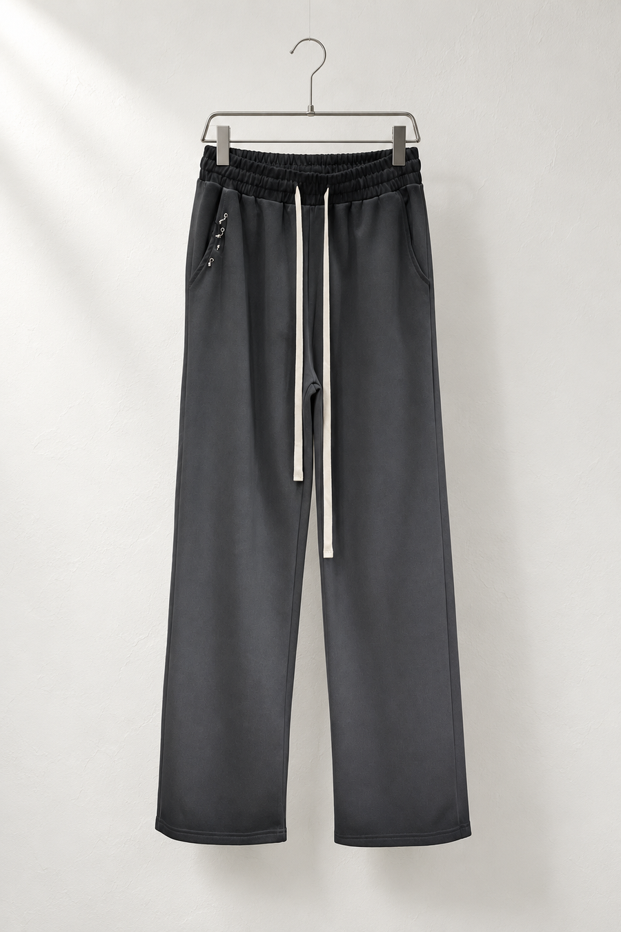 Pantaloni negri cu gradient pe umeraș metalic, talie închisă, șnururi ivoire și accesorii mici la buzunar