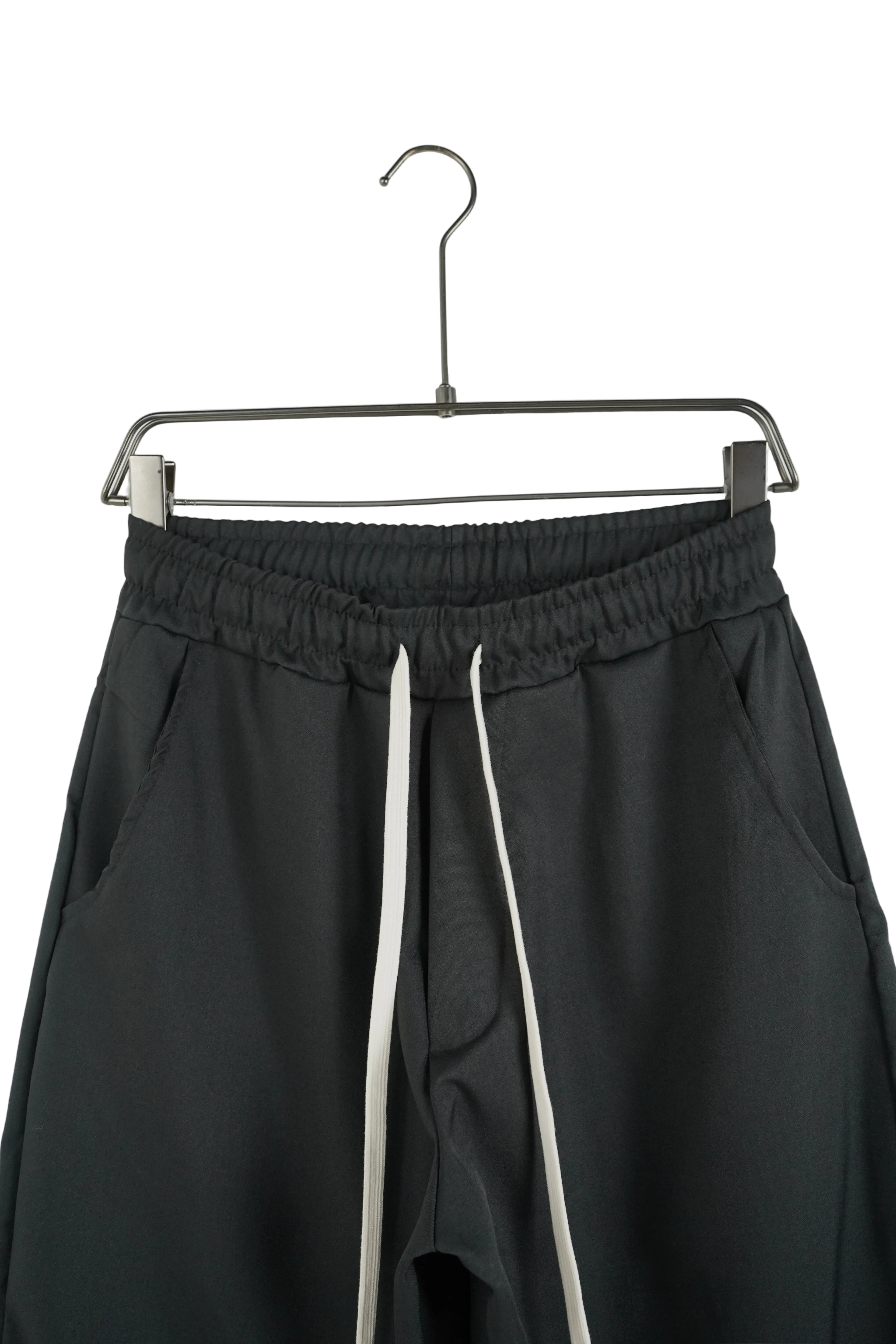 Pantalon streetwear negru model oversize cu șiret lung alb, vizibil pe fundal alb