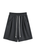 Pantaloni gri închis oversized cu șnur lung în talie, având o cusătură decorativă frontală pe centrul piciorului, confecționați dintr-un amestec de bumbac și poliester.
