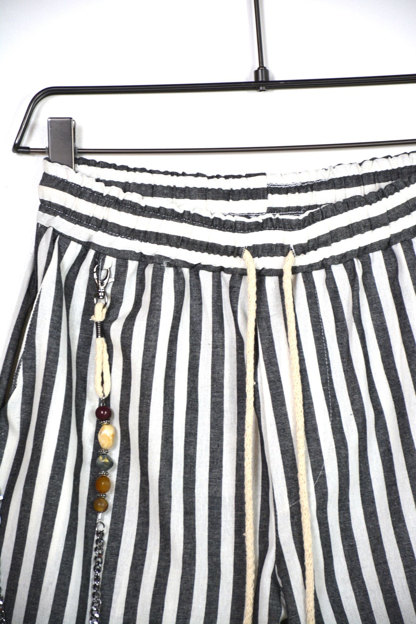 Model exclusivist de pantaloni cu șnur lung maro și mărgele, culoare gri cu dungi și buzunar cu fermoar