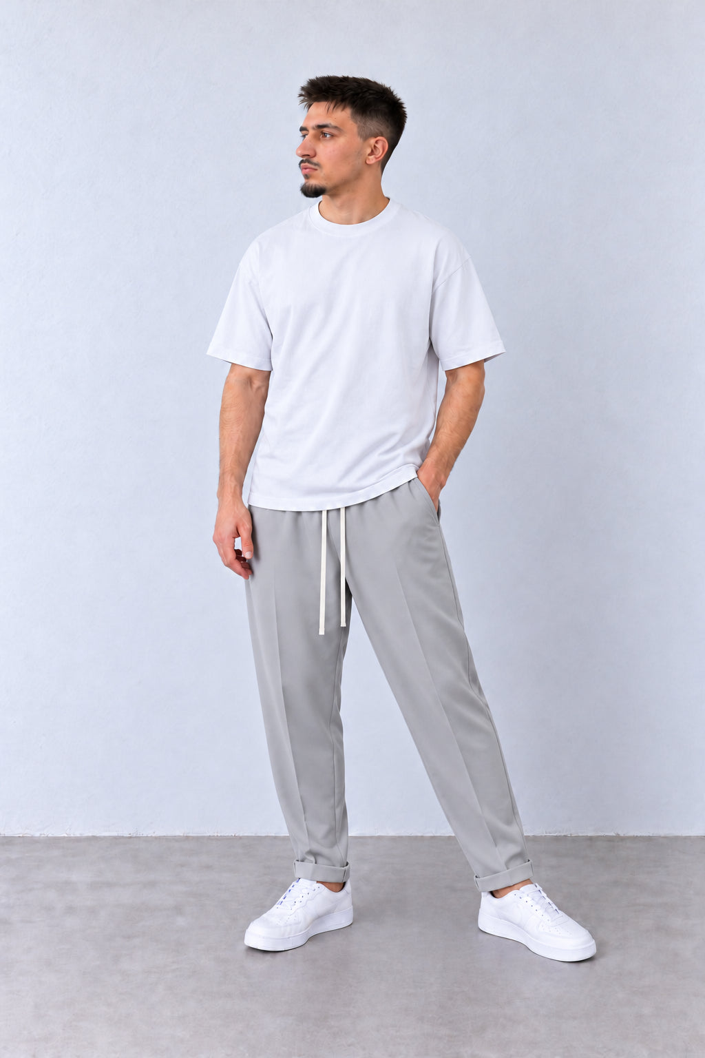 Pantaloni Slim Bărbați Gri cu Șnur Lung, vedere pe model cu poziție alternativă a brațelor și picioarelor.