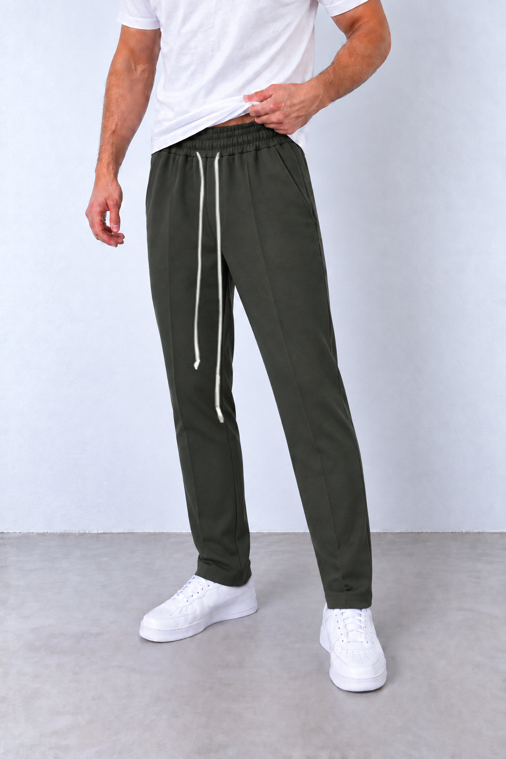 Pantaloni verde-militar ALLEN50 pe model, vedere din trei sferturi cu talie elastică, șnur lung și tivuri simple.