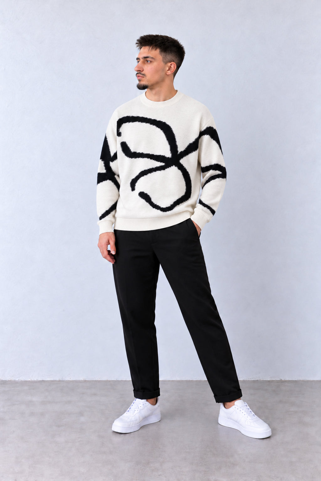 Pulover Bărbați Alb cu Model Abstract Negru, vedere pe model cu poziție alternativă a brațelor și picioarelor.