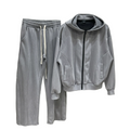 Bărbat purtând un set minimalist streetwear, format din hanorac cu fermoar și cusături arhitecturale vizibile, fără șiret la glugă, asortat cu pantaloni largi wide leg care au un șiret alb, lung și supradimensionat în talie