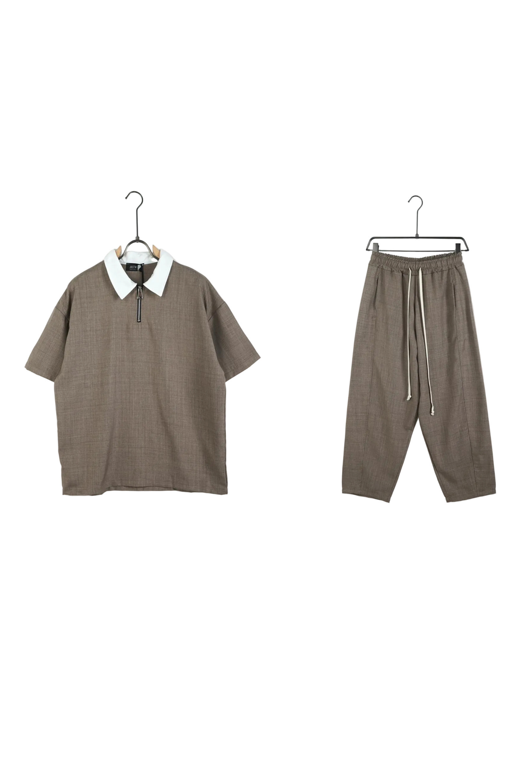 Set vestimentar maro cu croială largă, format dintr-un tricou polo cu fermoar și pantaloni ajustabili cu șiret lung