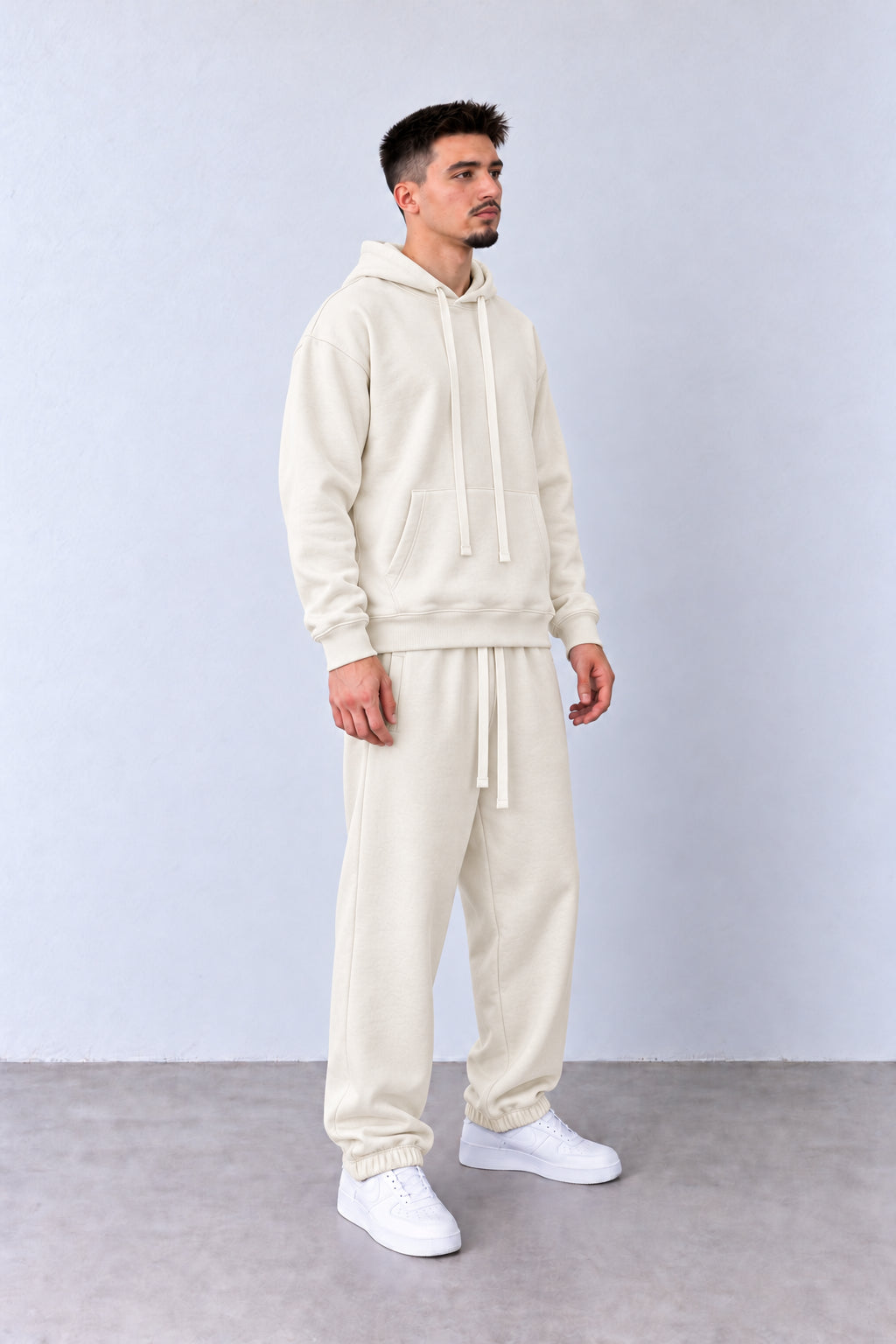 Trening Bărbați Crem cu Glugă și Pantaloni Jogger, vedere integrală pe model cu capul ușor întors sau înclinat.