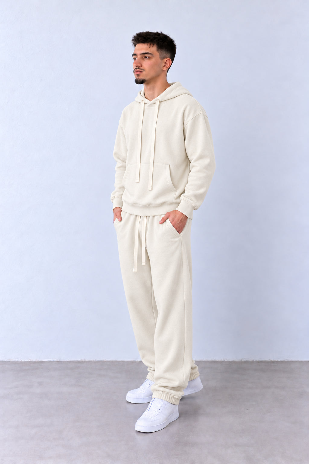 Trening Bărbați Crem cu Glugă și Pantaloni Jogger, vedere pe model cu poziție alternativă a brațelor și picioarelor.