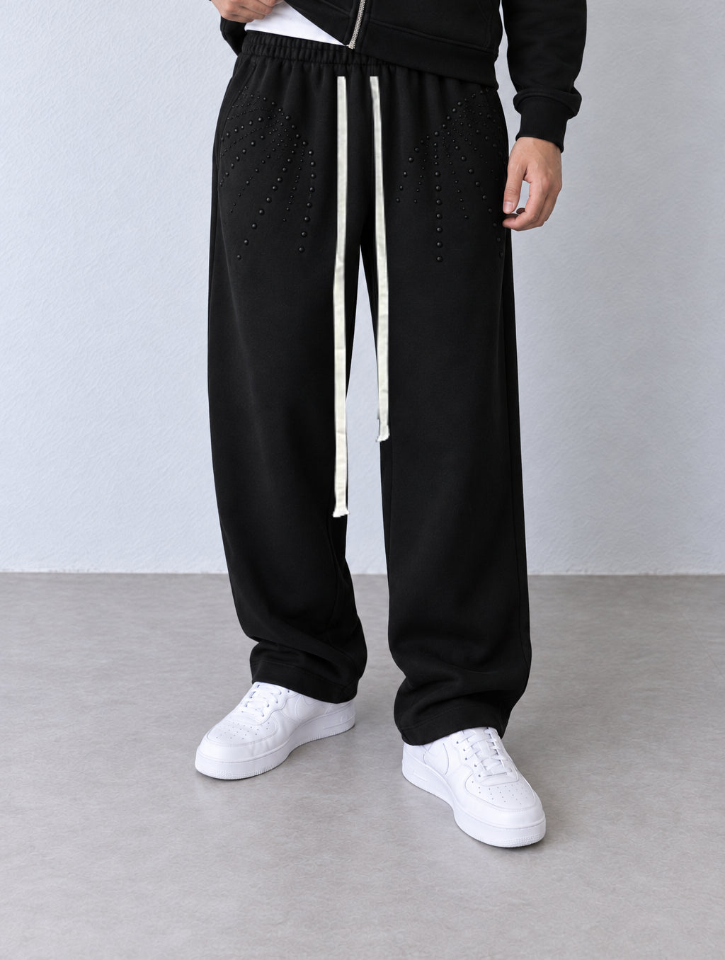 Pantaloni negri largi V3-1256A/B cu aplicații tonale și șnururi albe lungi, vedere din trei sferturi