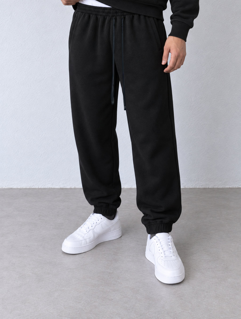 Pantaloni jogger negri 25600 cu șnururi negre și manșete elastice la glezne, vedere oblică