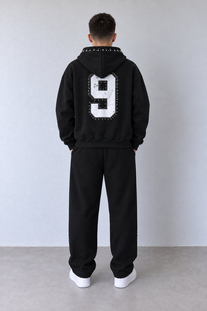 Trening negru B1-046 pe model din spate, cu numărul 9 alb pe hanorac și pantaloni largi