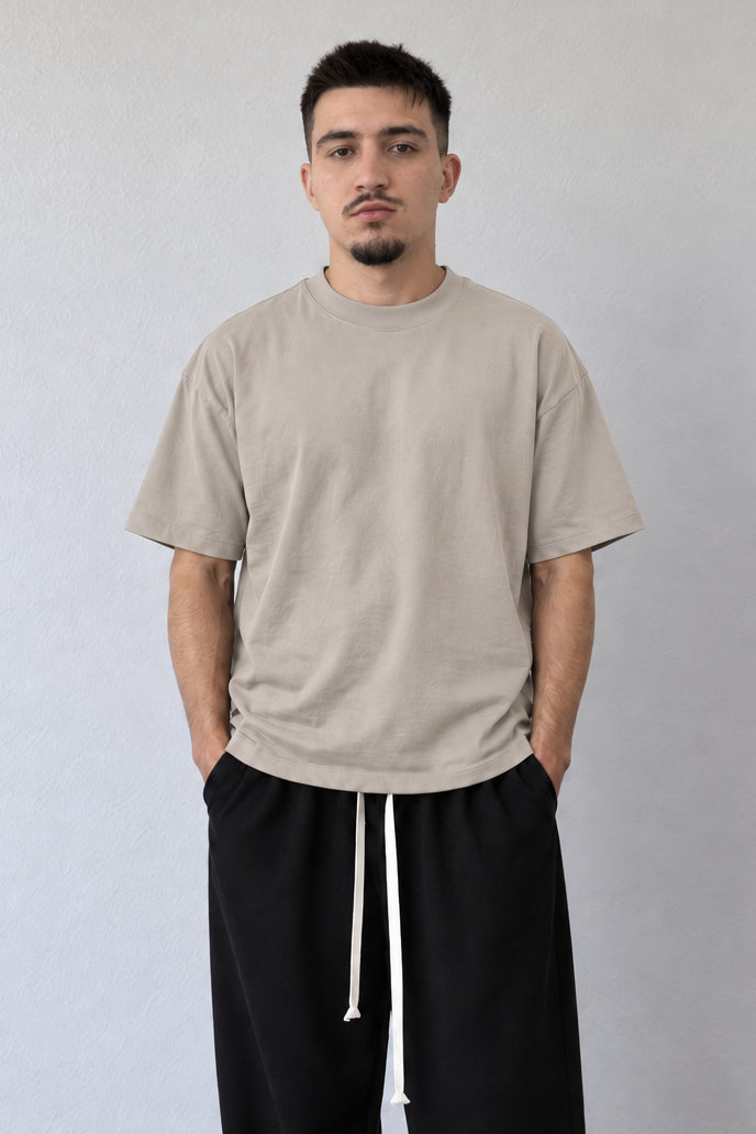 Tricou bej L815002, detaliu din față cu bordură reiată la gât, umeri căzuți și mâneci largi fără imprimeu.
